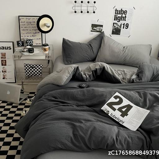 Four piece set of washed cotton quilt and solid color bed sheet on the bed